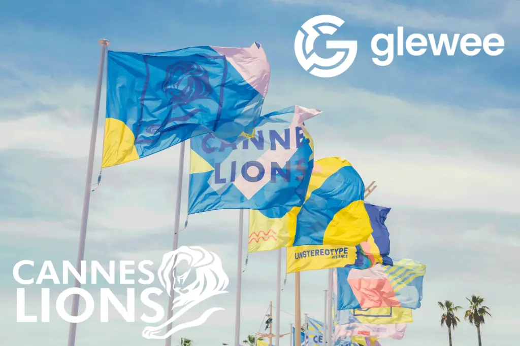 Flags in various colors reading Cannes Lions in front of a blue and white sky in the south of france