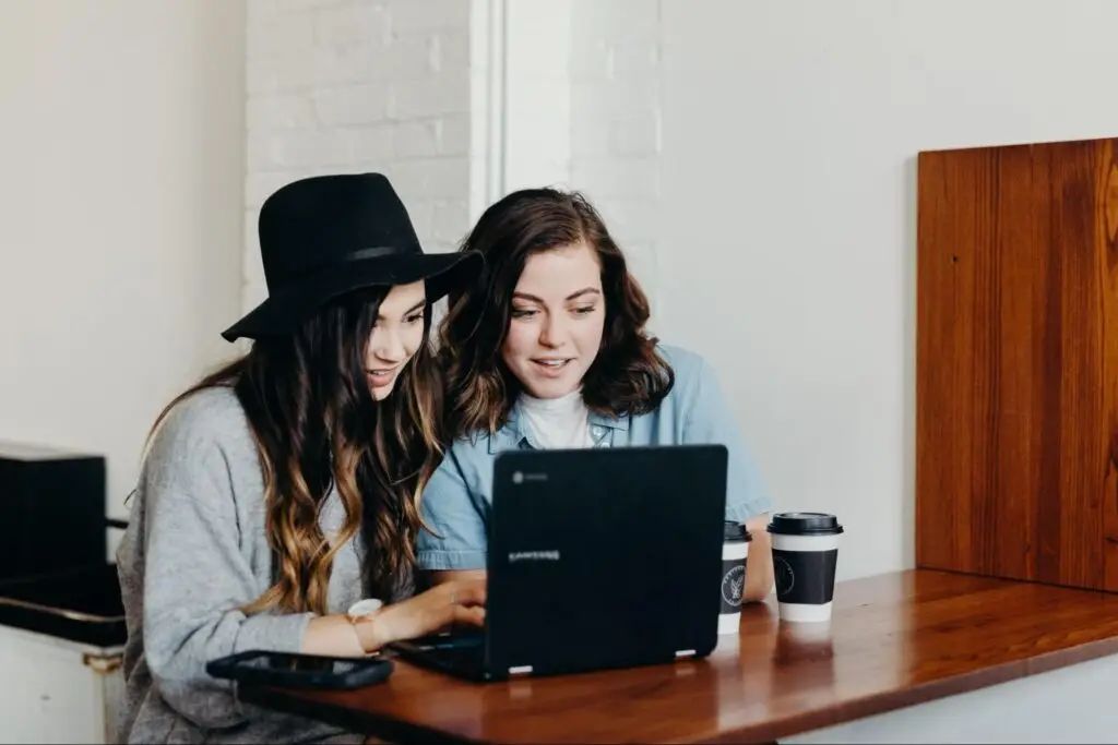 Two content creators looking at a laptop.