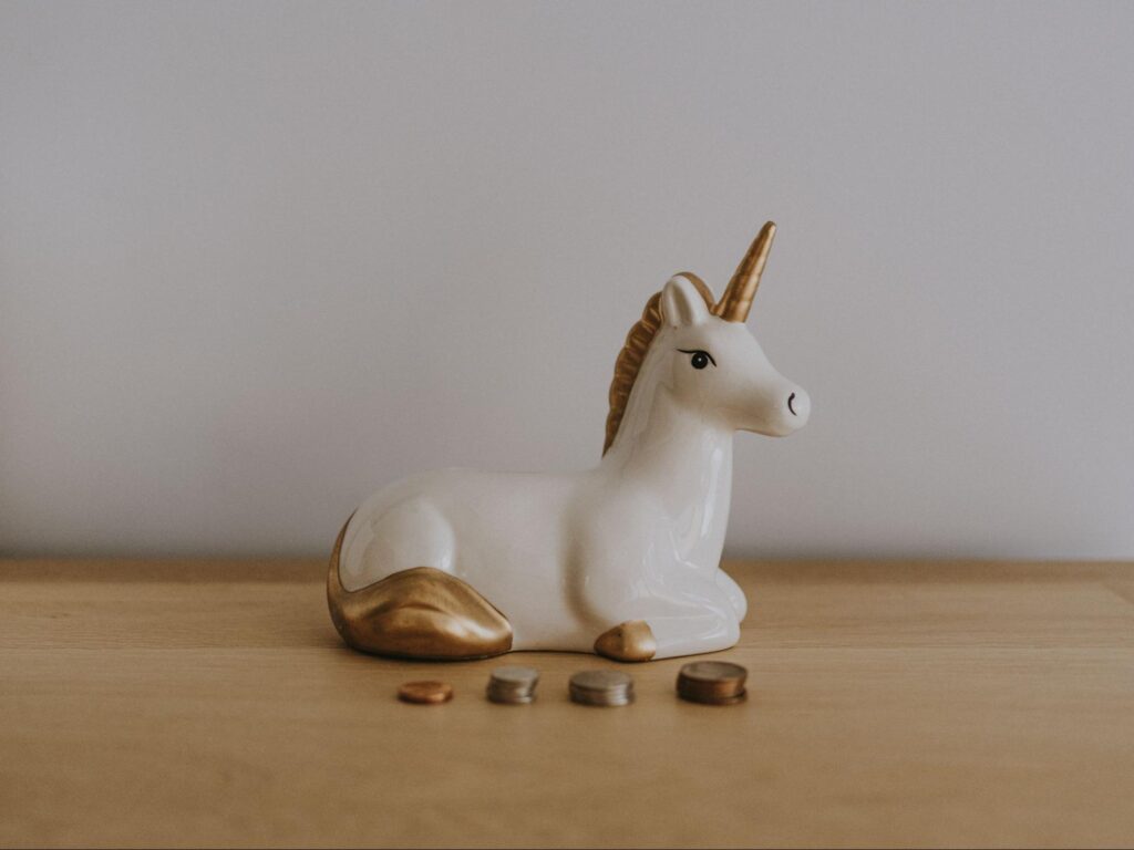 Unicorn statue behind a stack of pennies 