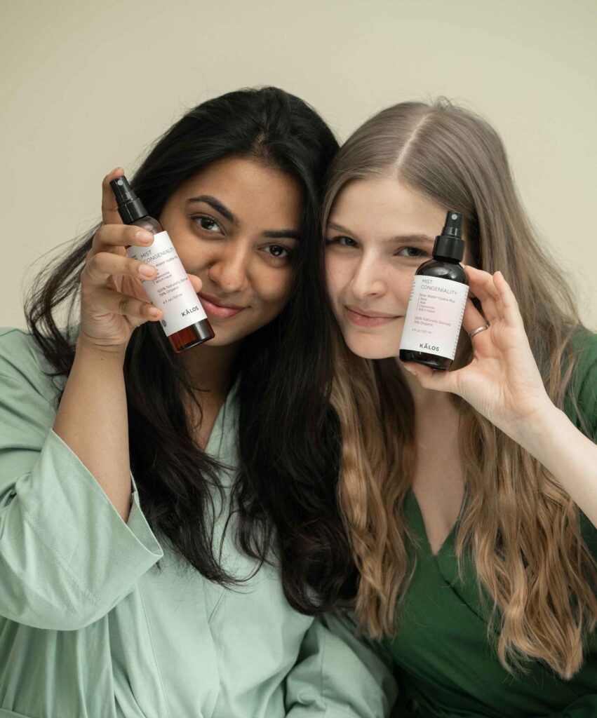 Two influencers hold two skincare products while facing the camera
