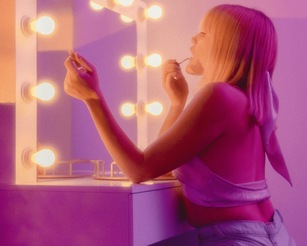 girl doing makeup in the mirror