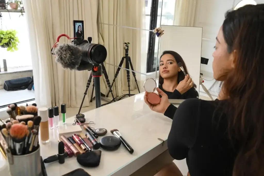 Woman in front of camera putting on makeup