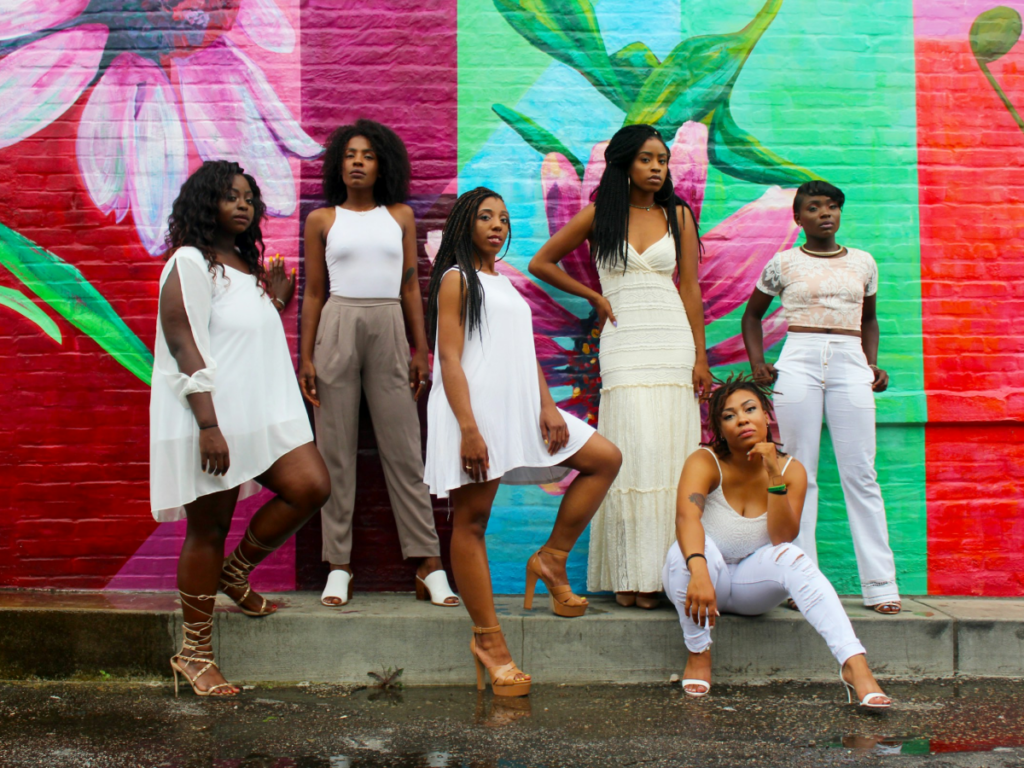 Group of people standing in front of a colored wall